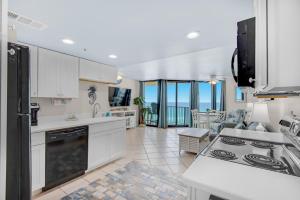 巴拿馬市海灘的住宿－Sunbird 709W Beach Life，一间厨房,配有白色的橱柜,享有海景