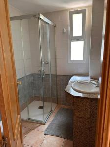 een badkamer met een douche en een wastafel bij espalmador II 7 bajo ALTA TURISTICA in Es Pujols