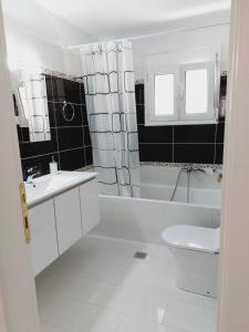 baño blanco con bañera, lavabo y aseo en Villa Daniela, en Loutraki 29 fotos más