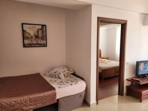 ママイアにあるApartment Rose Mamaia Nord Summerlandの小さなベッドルーム(ベッド1台、鏡付)