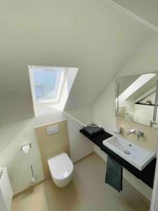 a bathroom with a toilet and a sink and a window at Altstadt Maisonette Wohnung in Brilon