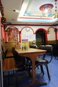 una sala da pranzo con tavolo e sedie in legno di Hotel Magnolia Mallroad Manali a Manāli