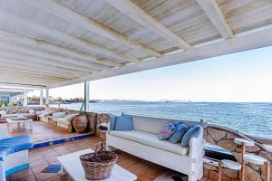 a porch with a couch on a boat on the water at Villa Vivimar in Siracusa