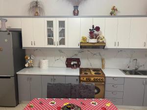 eine Küche mit weißen Schränken und einem Herd in der Unterkunft Vila Avni Likometi in Ksamil