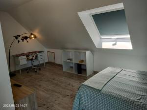 a bedroom with a bed and a desk and a window at Villa du Littoral in Mers-les-Bains