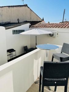 taras ze stołem, krzesłami i parasolem w obiekcie Maison 4 personnes avec jacuzzi w mieście Marignane