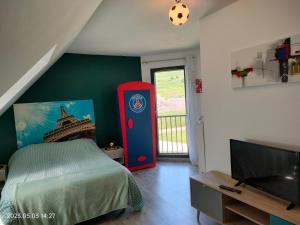 a bedroom with a bed and a tv in a room at Villa du Littoral in Mers-les-Bains