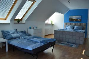 two beds in a room with blue walls and windows at Gemütlich in St. Margarethen in Sankt Margarethen