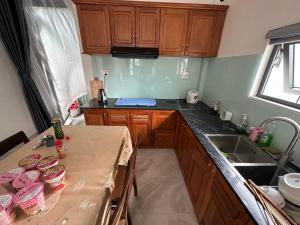 a kitchen with wooden cabinets and a table with food on it at 1994 House in Da Thanh