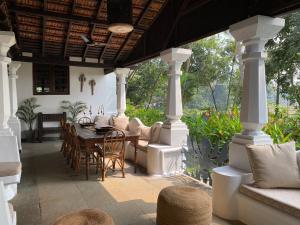 Verla的住宿－VILLA LOU GOA Heritage Portuguese House 1903 With Pool，门廊上配有桌椅的天井