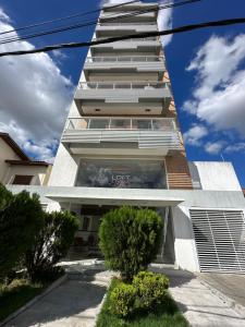 a tall white building with trees in front of it at Flat aconchegante próximo a Pelinca in Campos dos Goytacazes