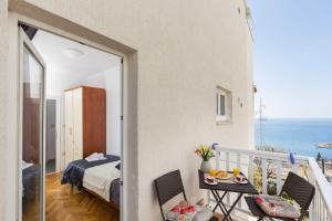 Doa - Apartment with Lovely Terrace & Sea View في مْليني: شرفة مطلة على غرفة نوم والمحيط