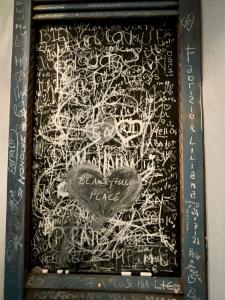 a painting with writing on a black board at Chez Cécile Home in Mochlos