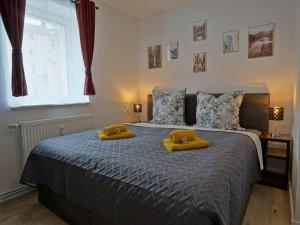 1 dormitorio con 1 cama con 2 almohadas amarillas en "HOGULU" Brandenburg, Balkon, Neustadt, Küche, Wassernähe - Parkplatz inklusive en Brandenburg