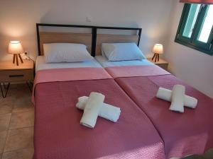 a bedroom with a bed with two towels on it at Aurora Andros House in Korthi