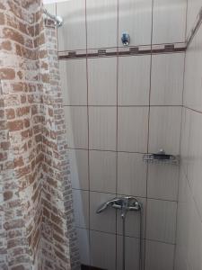a shower in a bathroom with a brick wall at Aurora Andros House in Korthi +30 photos