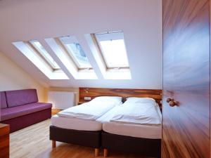 a bedroom with a bed and a couch with skylights at Villa Ceconi by Das Grüne Hotel zur Post - 100% BIO in Salzburg