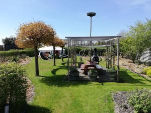 einen Garten mit einem Picknicktisch und einer Schaukel in der Unterkunft T'eiberveld Yurt verhuur Noord-Sleen in Noord-Sleen