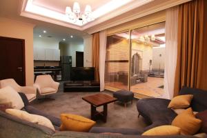 un soggiorno con divano, sedie e TV di شاليهات أندلوسيا a Riyad