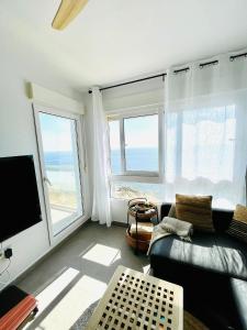 un soggiorno con divano, TV e finestre di Apartamento El Osito a La Manga del Mar Menor
