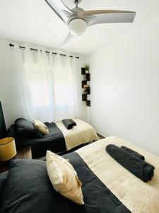 una camera con 2 letti e un ventilatore a soffitto di Apartamento El Osito a La Manga del Mar Menor