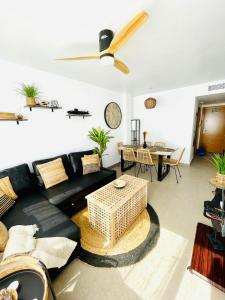 un soggiorno con divano nero e tavolo di Apartamento El Osito a La Manga del Mar Menor