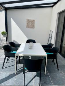 een witte tafel en stoelen op een patio bij Vakantiewoningen Bienvenue, Le Pont in Lanaken