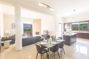 kuchnia i salon ze stołem i krzesłami w obiekcie Sparta Luxury Villa w mieście Protaras