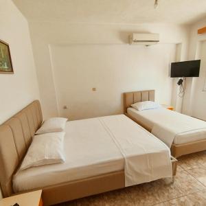 Mejdi Apartments في سارنده: غرفة نوم بسريرين وتلفزيون فيها