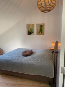 uma cama num quarto com duas fotografias na parede em Vakantiewoningen Bienvenue, Le Pont em Lanaken