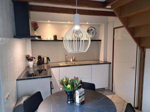 a kitchen with a table with a vase of flowers on it at Onder de Boomen in Bergen