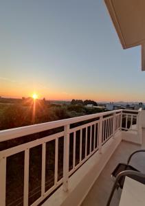 a balcony with a view of the sunset at Swallow's Nest Apartment in Paradeísion