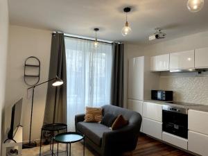a living room with a couch and a kitchen at Appartement en Centre-Ville in Brest