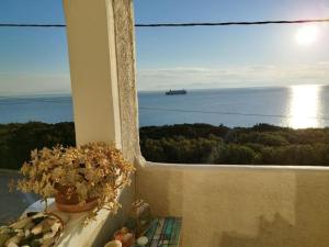 une fenêtre avec vue sur l'océan et un bateau dans l'établissement Indigo, à Rafína