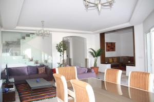 a living room with a purple couch and chairs at Villa Kenais Sunset in Taguermess