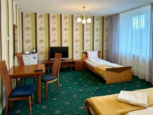Pokój hotelowy z sypialnią z biurkiem i łóżkiem w obiekcie NARAMOWICE Hostel by Przyjazny Najem w Poznaniu