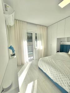 um quarto branco com uma cama e uma janela em Durres Currila SUNSET Beach Beaty em Durrës