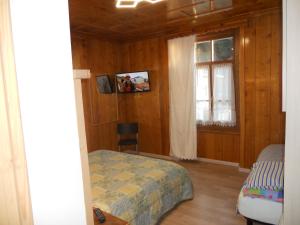 Schlafzimmer mit einem Bett und einem Fenster in der Unterkunft Casa Alberti in Valfurva