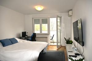 a bedroom with a bed and a desk and a window at Stinga apartment in Zagreb