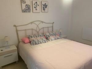 a bedroom with a white bed with pillows on it at Céntrico in Antequera