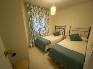 a small room with two beds and a window at Céntrico in Antequera