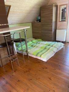 Cama en habitación con mesa y sillas en Rustic private Cabin in woods w/ Sauna & Pool en Vilna
