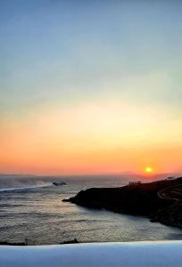 a sunset over a body of water with the ocean at Aegean living Villa in Agios Romanos