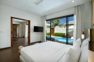 a bedroom with a large bed and a pool at The Claremont Luxury Villas in Seminyak