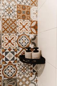 a bathroom with a tile wall with two towels on a shelf at Studio Apartment Bohemia in Mostar