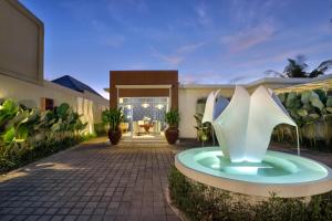 a house with a fountain in the middle of a courtyard at The Claremont Luxury Villas in Seminyak