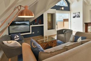 a living room with two couches and a tv at Villa Yvantino in Saint Barthelemy