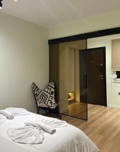 una camera con letto, sedia e specchio di 4SeasonsGea , Cozy Studio In Central Position , Tirana a Tirana