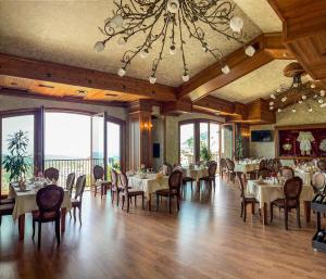 a dining room with tables and chairs and a chandelier at Hotel Kroi near castle entrance castle and town view in Krujë