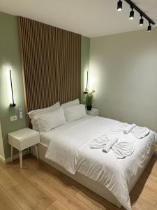 una camera da letto con un letto bianco con due asciugamani di 4SeasonsGea , Cozy Studio In Central Position , Tirana a Tirana